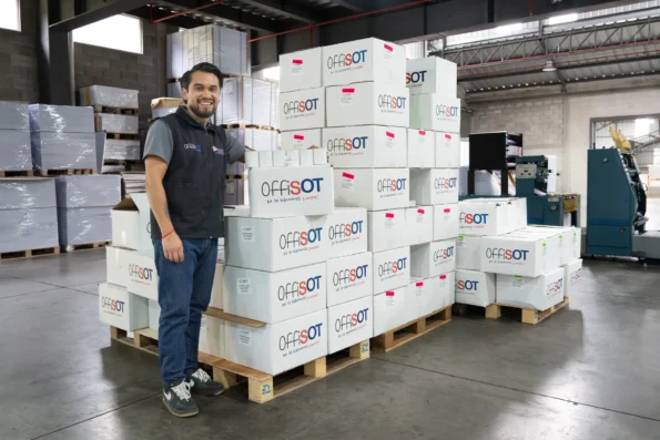 Colaborador junto a cajas OffiSot en la planta de Imporsopapel